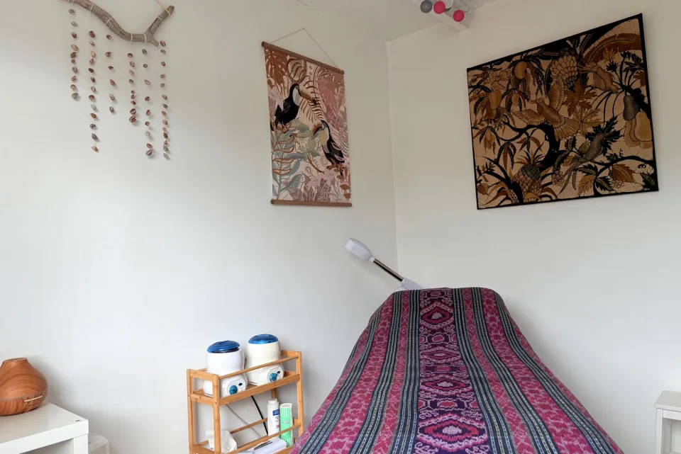 Détail de la cabine de soins de l'institut elena à Bois Rouge, Saint-Paul : table de massage et décoration murale.