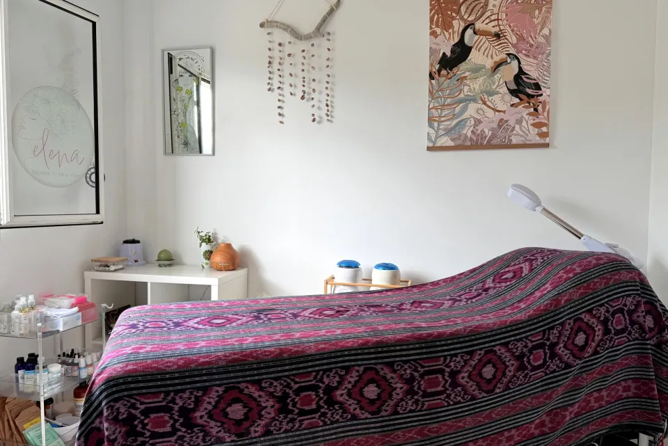 Table de massage et chariot de produits dans la cabine de soins de l'institut elena à Bois Rouge, Saint-Paul.